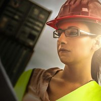 Headshot of woman with a hard hat working on site.