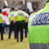 Police officer up close with other police officers in the background.