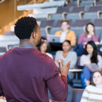 An image of a young woman speaking to two work colleagues.